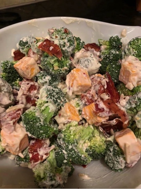 Picture of made broccoli salad with cheese, bacon, and broccoli in a white bowl